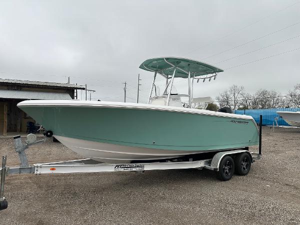 Aquasport 22AS 2024 Aquasport 22AS boat on a trailer, side view, teal hull, white top.
