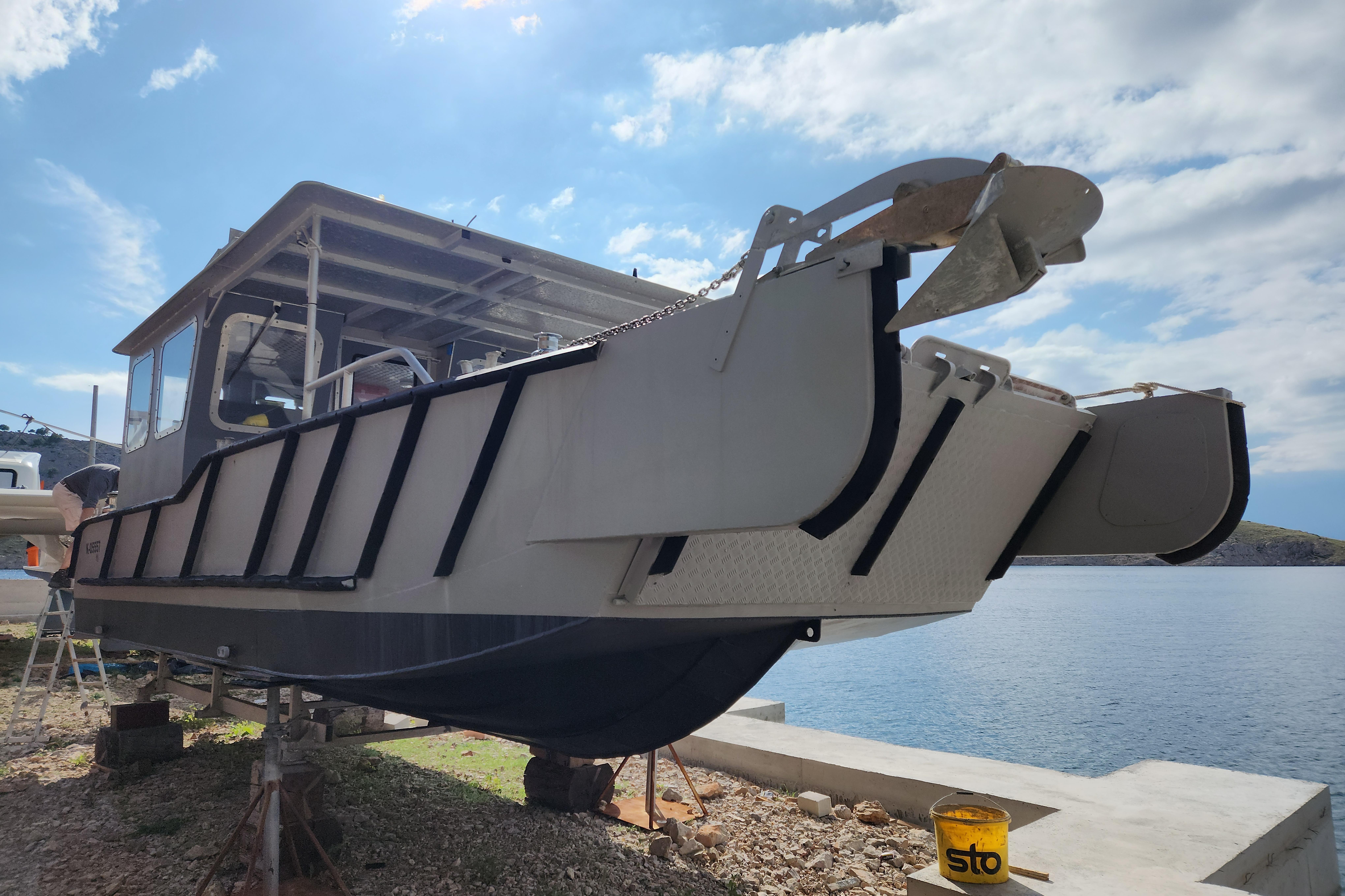 Custom LC 853 Aluminum boat ALUTEH LC 853, 2018 model, docked by the water under a clear sky.
