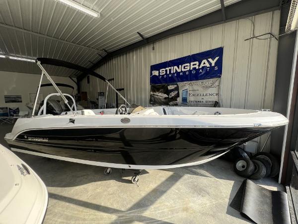 Stingray 172SC 2025 Stingray 172SC boat in showroom, black and white design, under indoor lighting.
