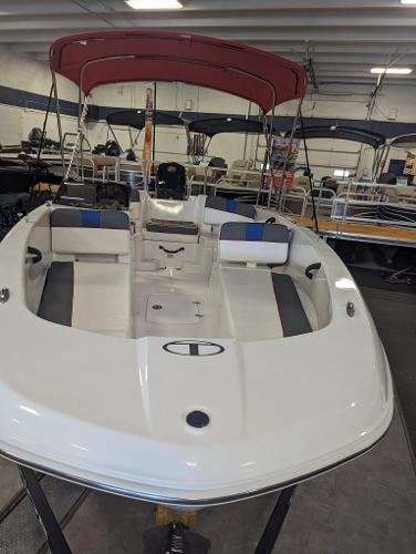 Tahoe T18 2024 Tahoe T18 boat with red canopy in showroom.