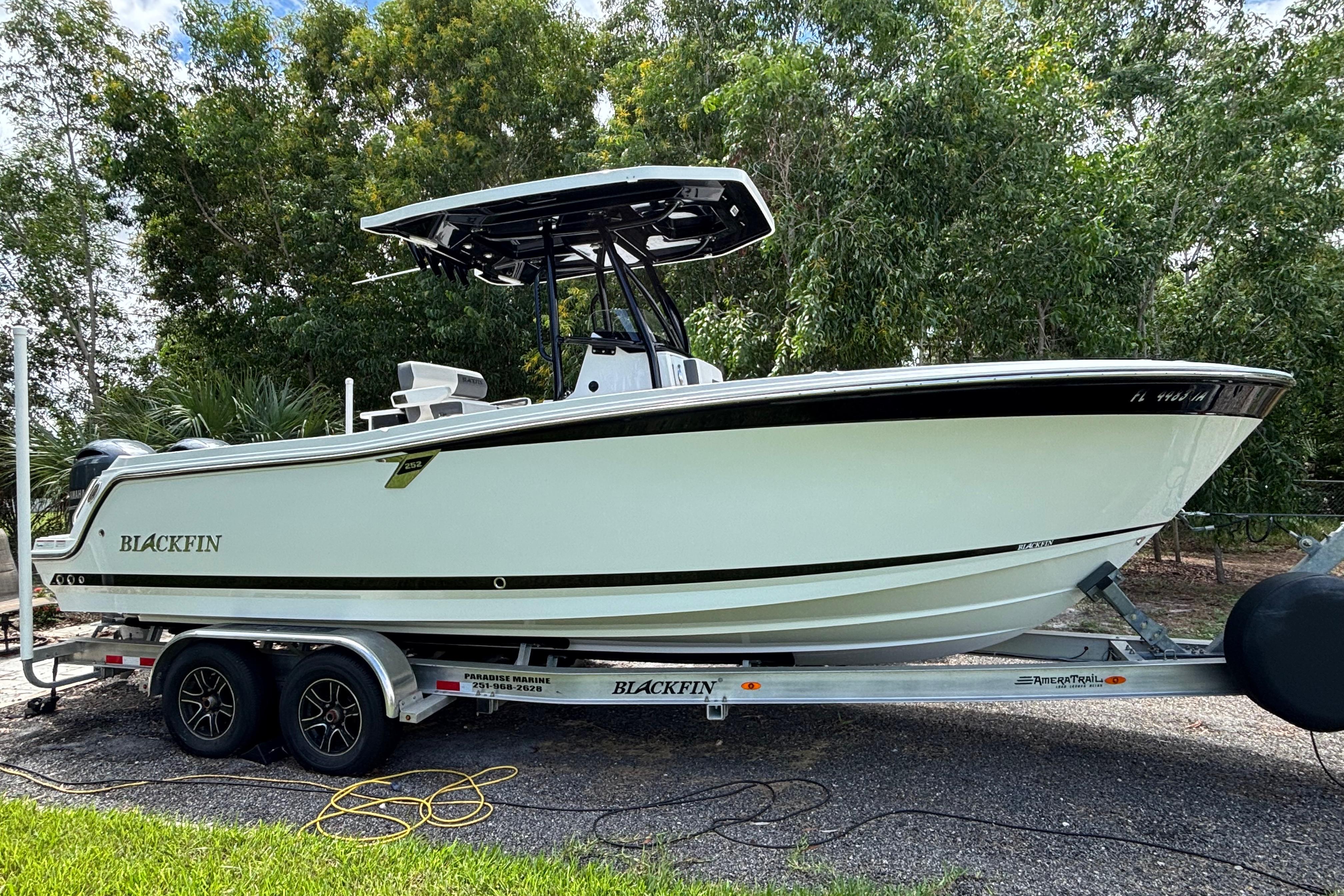 Blackfin 252 CC 2020 Blackfin 252 CC boat on trailer, surrounded by lush greenery.