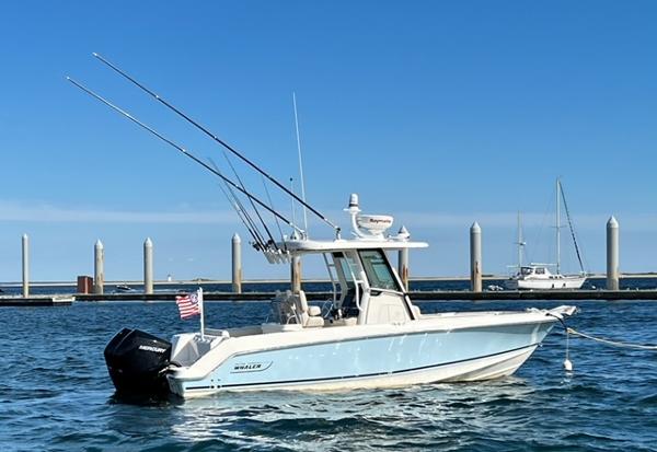 Boston Whaler 250 Outrage 2022 Boston Whaler 250 Outrage boat docked in marina, clear blue sky.