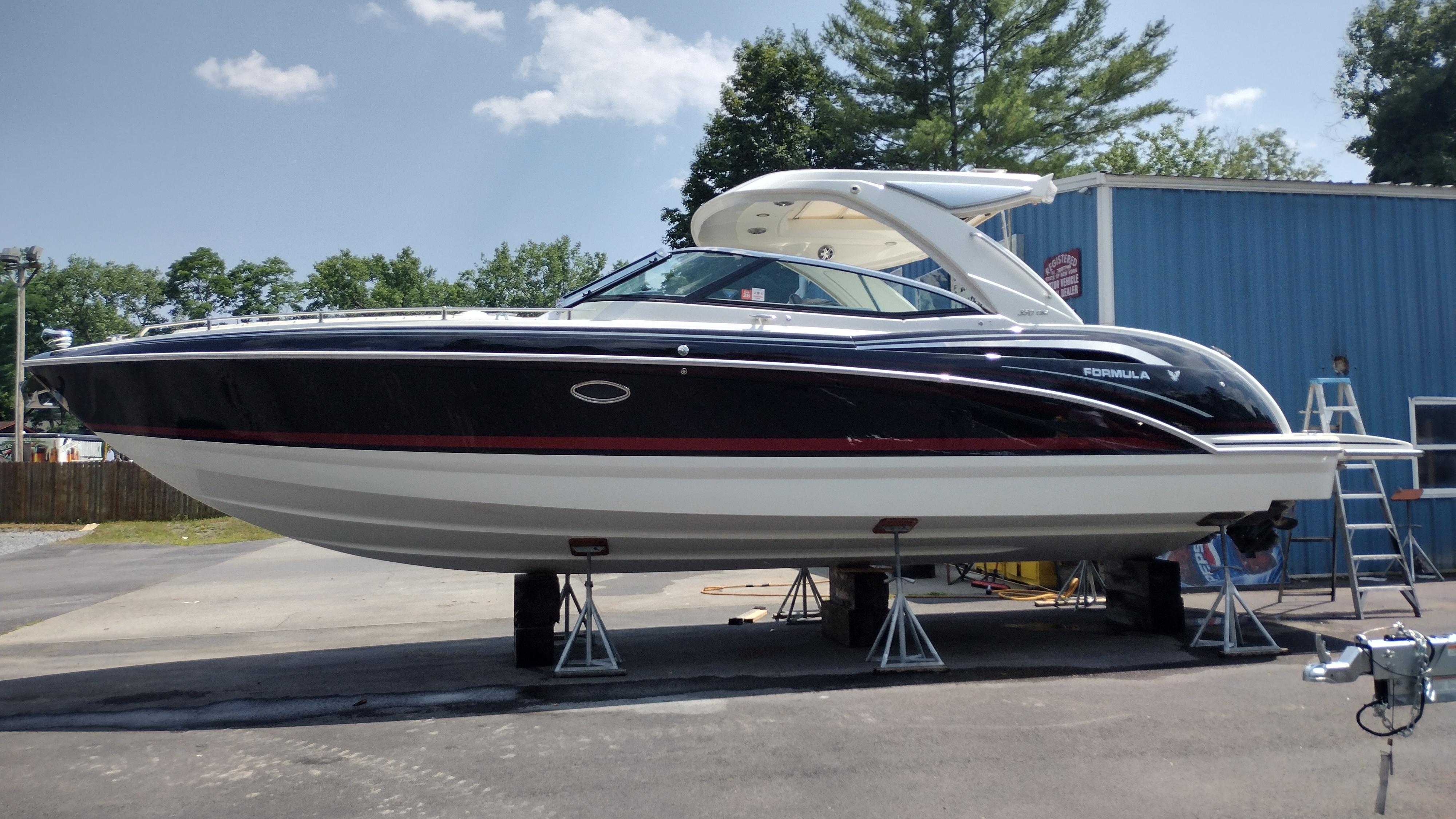 Formula 350 CBR 2020 Formula 350 CBR boat on stands, outdoors near a blue building.