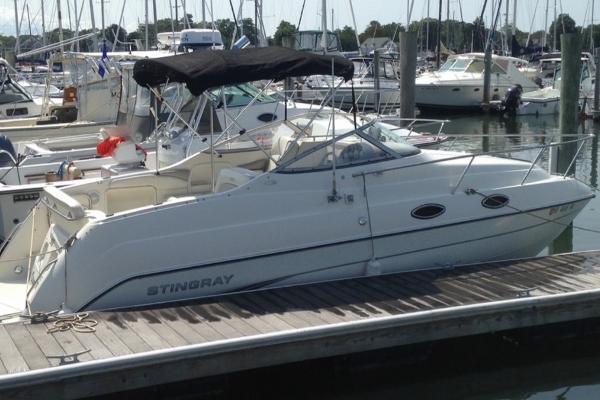 Stingray 240 CS 2004 Stingray 240 CS boat docked at marina with canopy and sleek design.