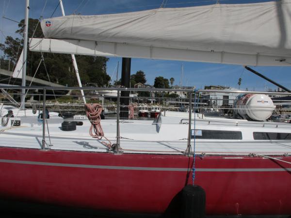 Santa Cruz 70 1985 Santa Cruz 70 sailboat with red hull docked at marina.