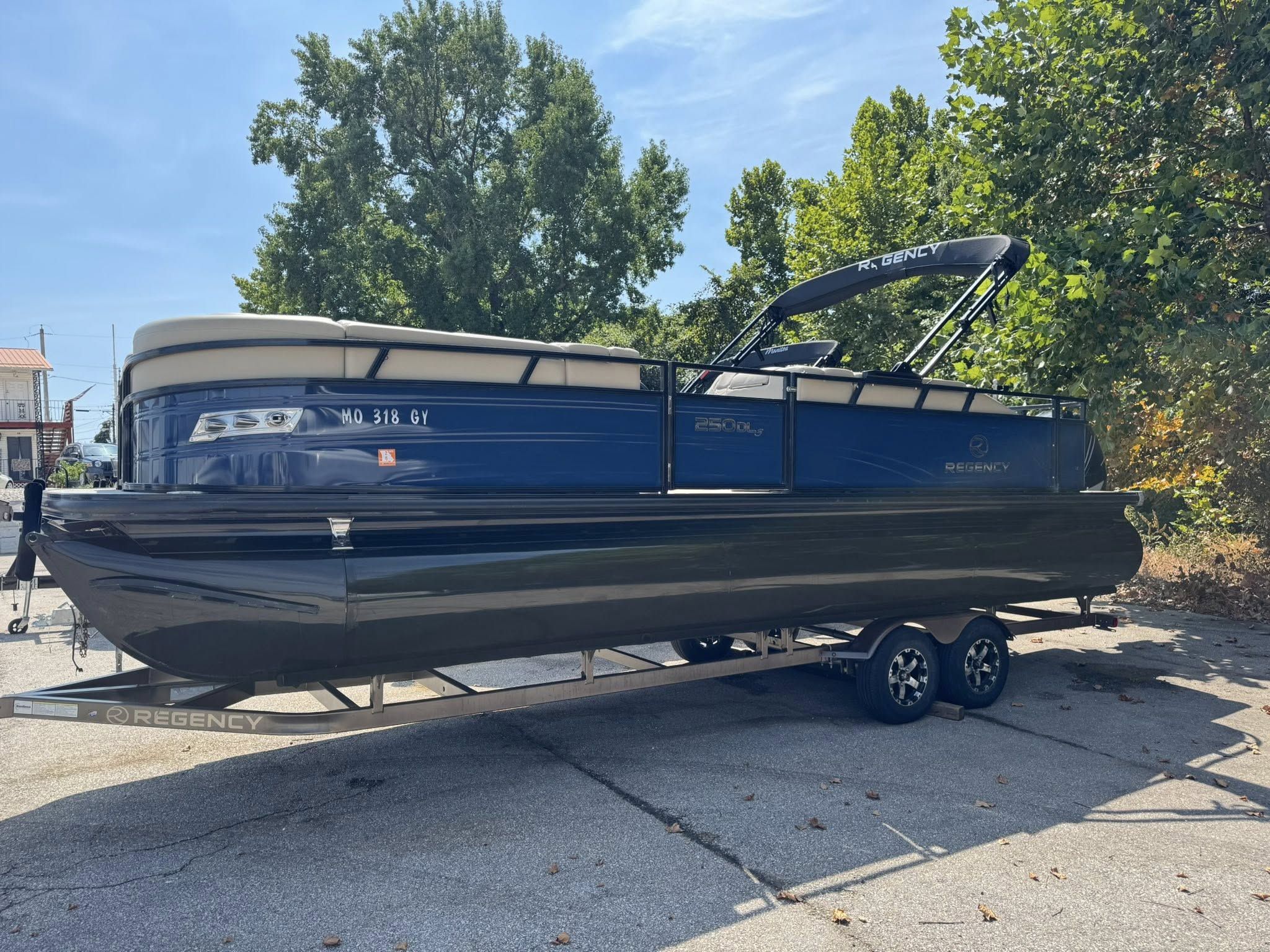 Regency 250 DL3 2023 Regency 250 DL3 pontoon boat on trailer, parked outdoors.