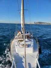 Custom Chiquita 39 Sailing yacht "Chiquita 39" cruising on blue ocean near city skyline, clear sky.
