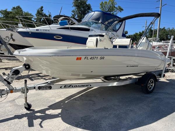 Stingray 186 CC 2020 Stingray 186 CC boat on trailer, parked outdoors, with other boats in the background.