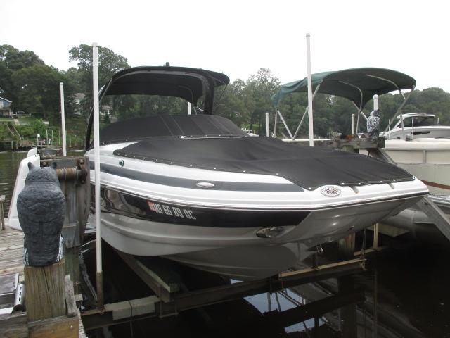 Crownline E260XS 2016 Crownline E260XS boat docked with cover, surrounded by trees and other boats.
