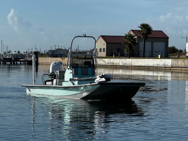 Majek 21RFL 2023 Majek 21RFL boat on calm water near a dockside building.
