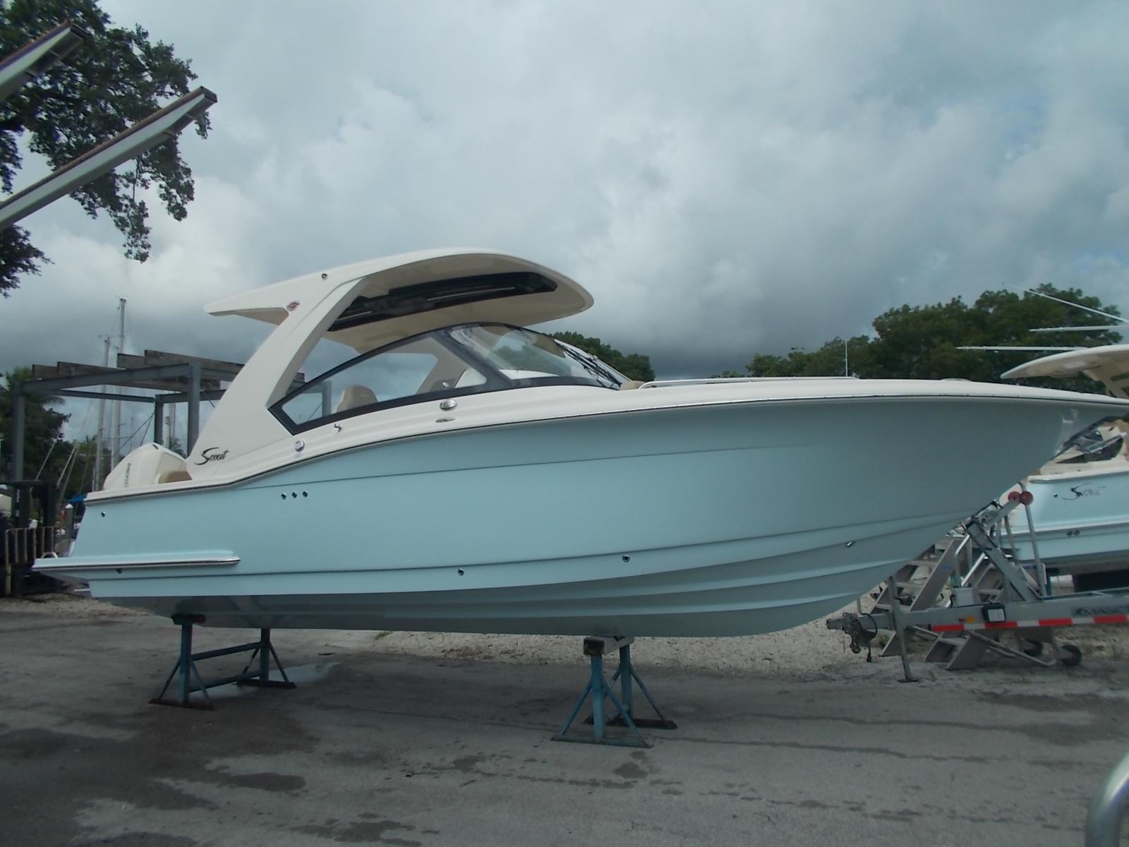Scout 277 Dorado 2025 Scout 277 Dorado boat on stands, light blue hull, dockside.