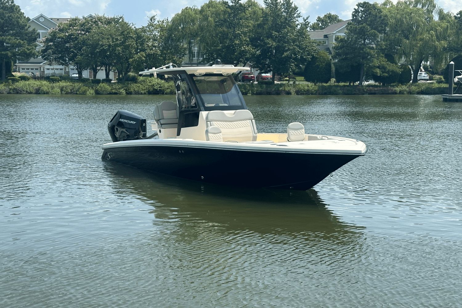Scout 261 XSS 2025 Scout 261 XSS boat on calm lake with trees in background.