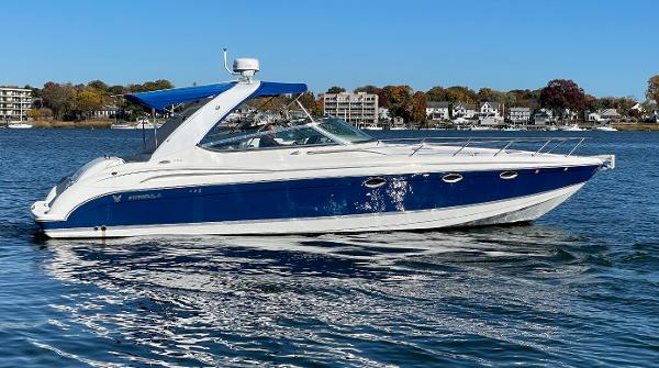 Formula 370 Ss 2003 Formula 370 SS boat on calm water, blue and white design, clear sky background.