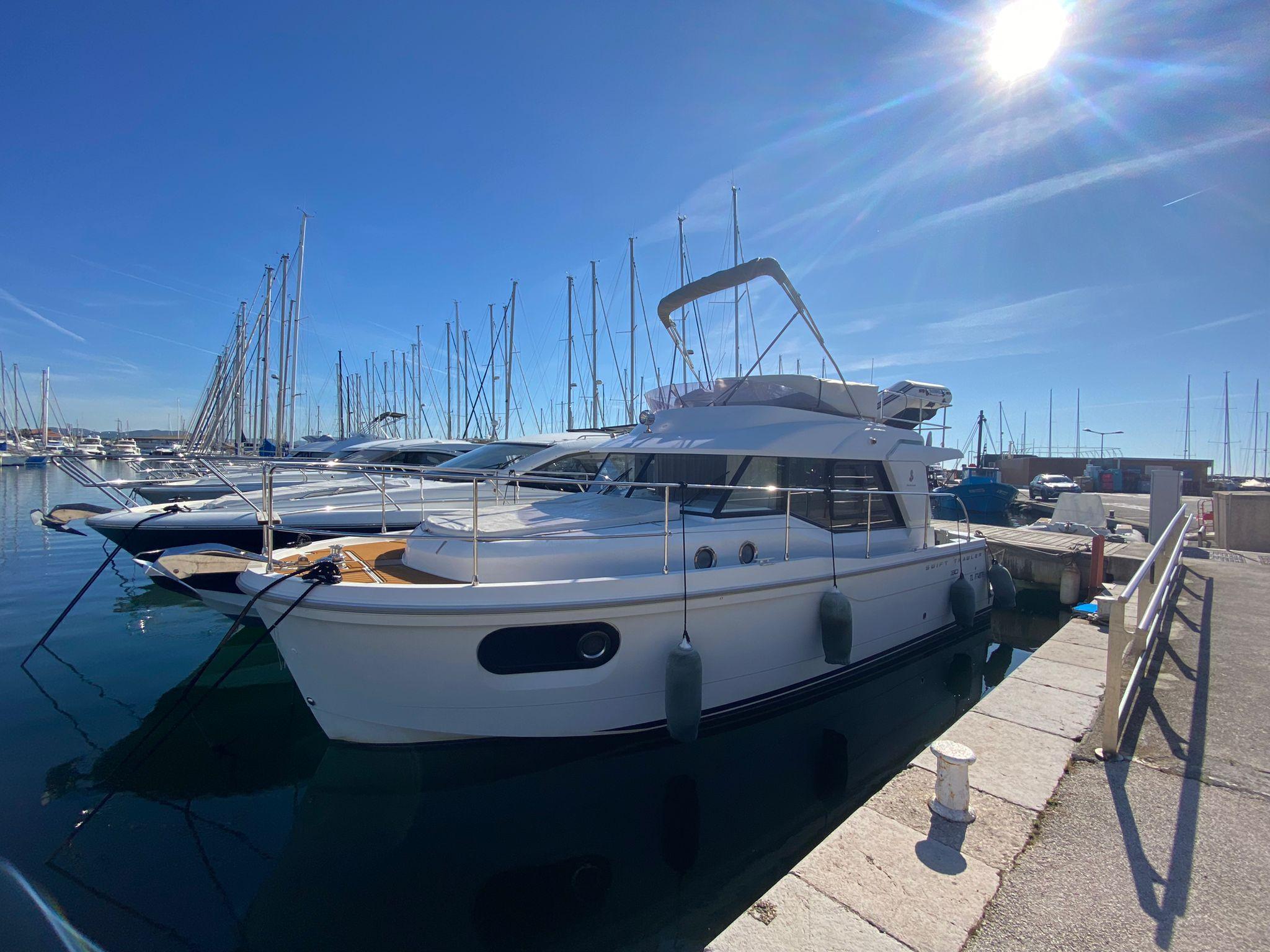Beneteau Swift Trawler 30 2016 Beneteau Swift Trawler 30 docked in a sunny marina.