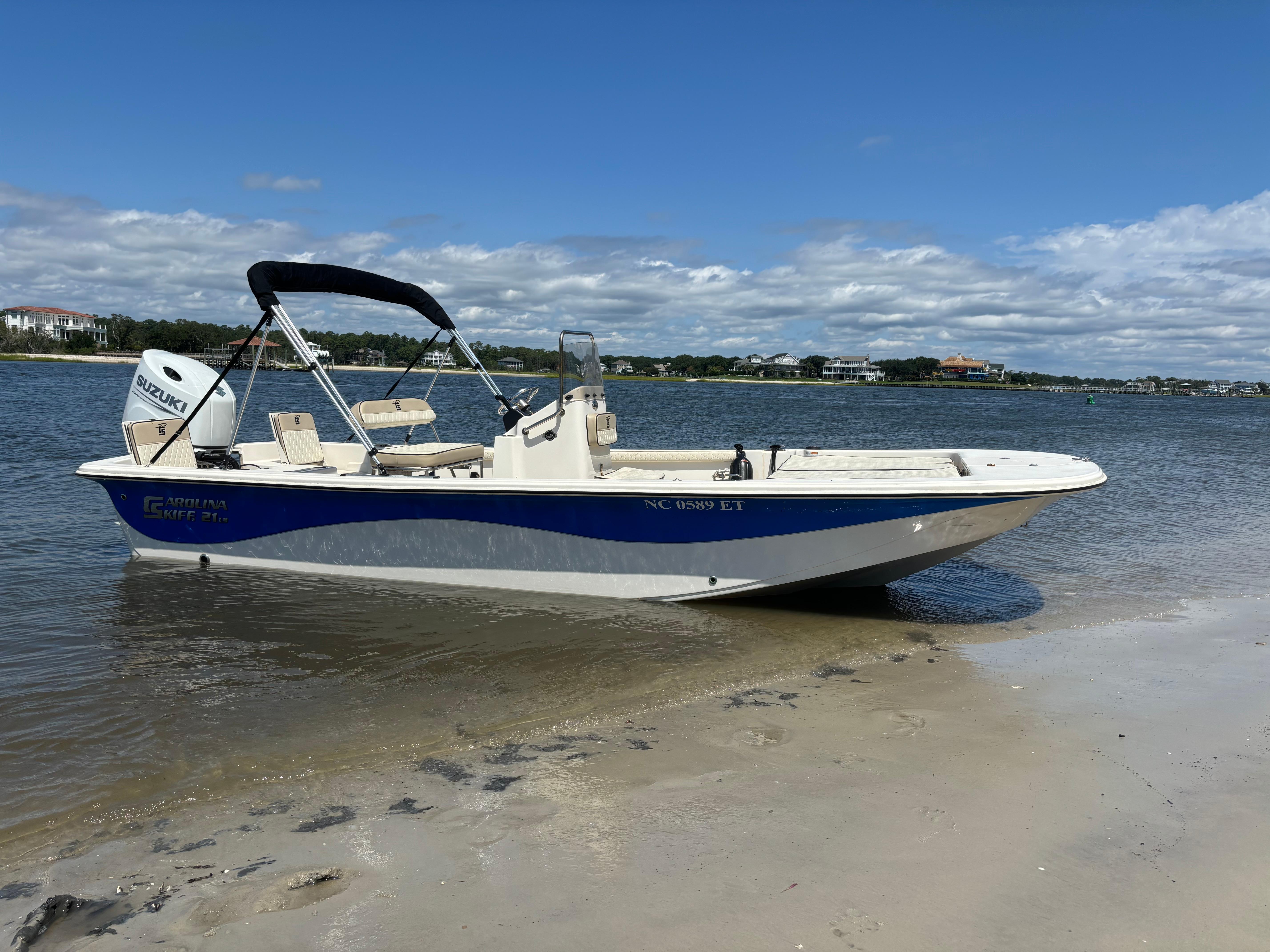 Carolina Skiff 21 LS 2021 Carolina Skiff 21 LS boat on sandy shore with clear blue sky.