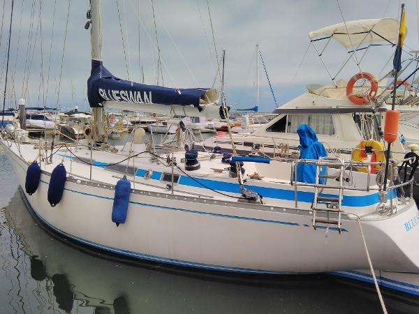 Nautor Swan 411 1977 Nautor Swan 411 sailboat docked in marina, featuring blue accents and protective fenders.