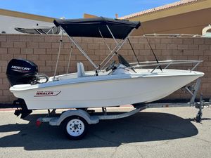 Boston Whaler 130 Super Sport 2021 Boston Whaler 130 Super Sport boat on trailer, with Mercury engine, parked outdoors.