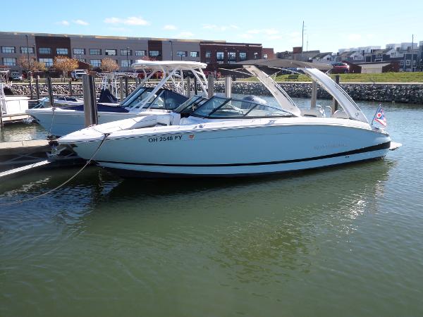 Regal LS6 2020 Regal LS6 boat docked in marina, calm water, clear sky.