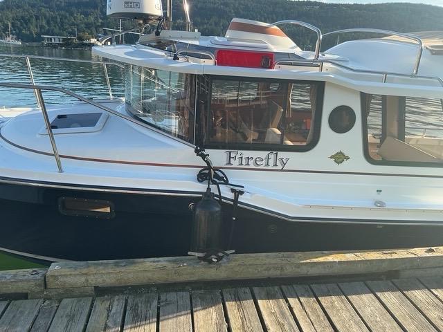 Ranger Tugs R23 2017 Ranger Tugs R23 boat named "Firefly" docked by a scenic waterfront.