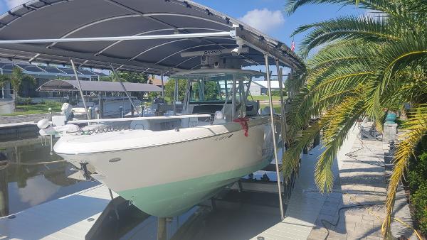 Wellcraft 352 Fisherman 2023 Wellcraft 352 Fisherman boat docked under a canopy, surrounded by palm trees.