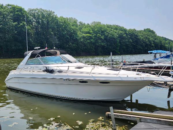 Sea Ray 330 Sundancer 1998 Sea Ray 330 Sundancer boat docked on a calm lake with lush green trees.