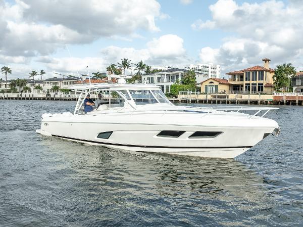 Intrepid 409 Valor 2021 Intrepid 409 Valor boat cruising on a scenic waterfront.