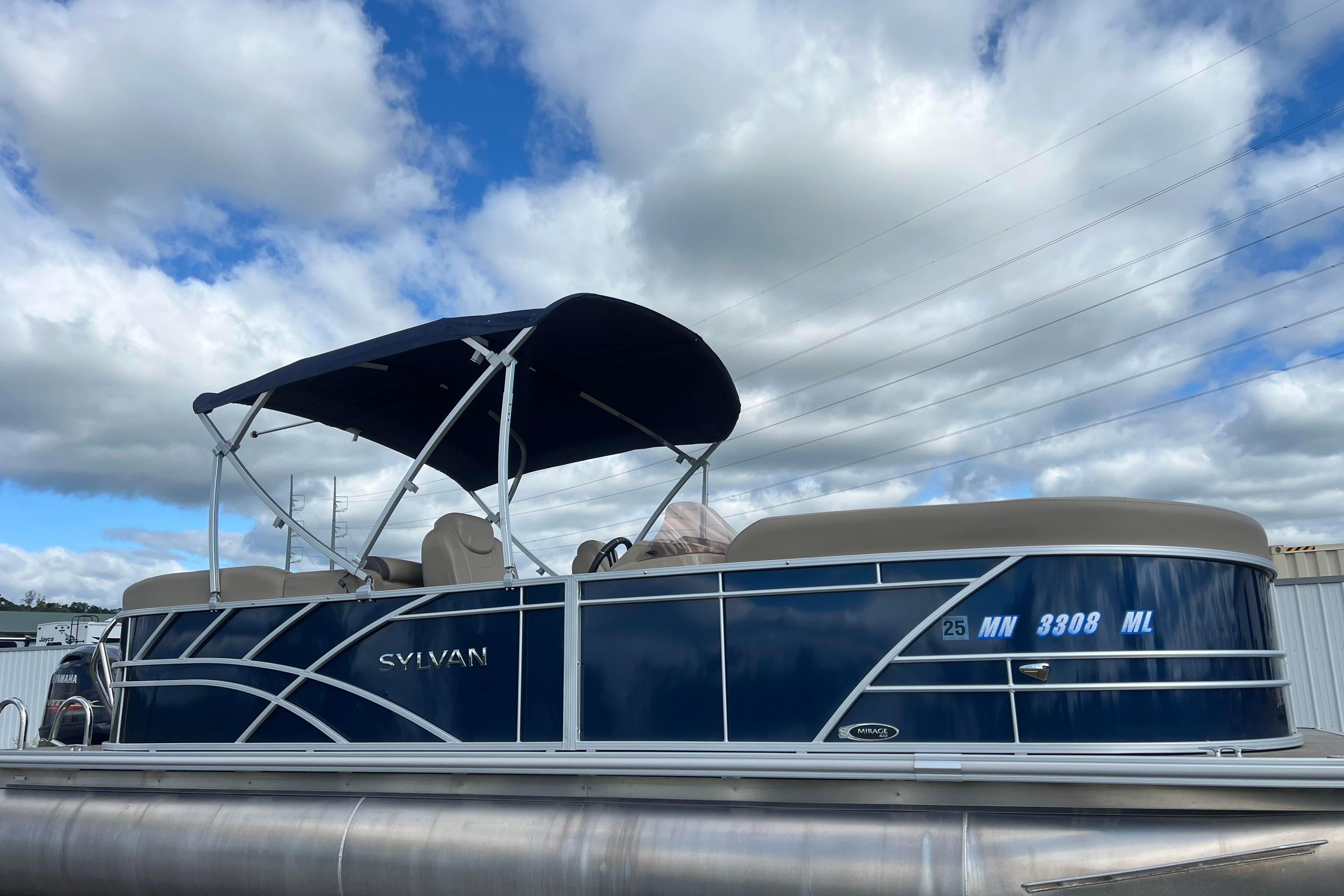 Sylvan Mirage 822 LZ 2023 Sylvan Mirage 822 LZ pontoon boat with canopy, parked under a cloudy sky.