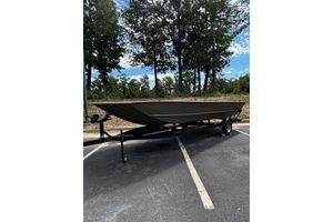 Tracker Grizzly 2072 Utility 2025 Tracker Grizzly 2072 Utility boat on trailer in parking lot, surrounded by trees.