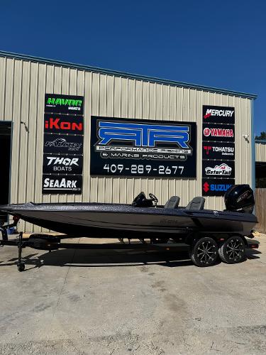 iKon VLX21 iKon VLX21 boat 2025 model displayed outside marine shop with various brand logos.