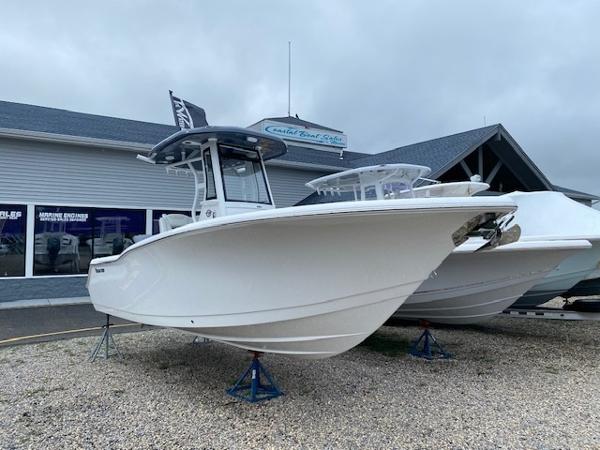Tidewater 232cc / LXF 2026 Tidewater 232cc/LXF boat displayed outdoors on stands, near a coastal building.