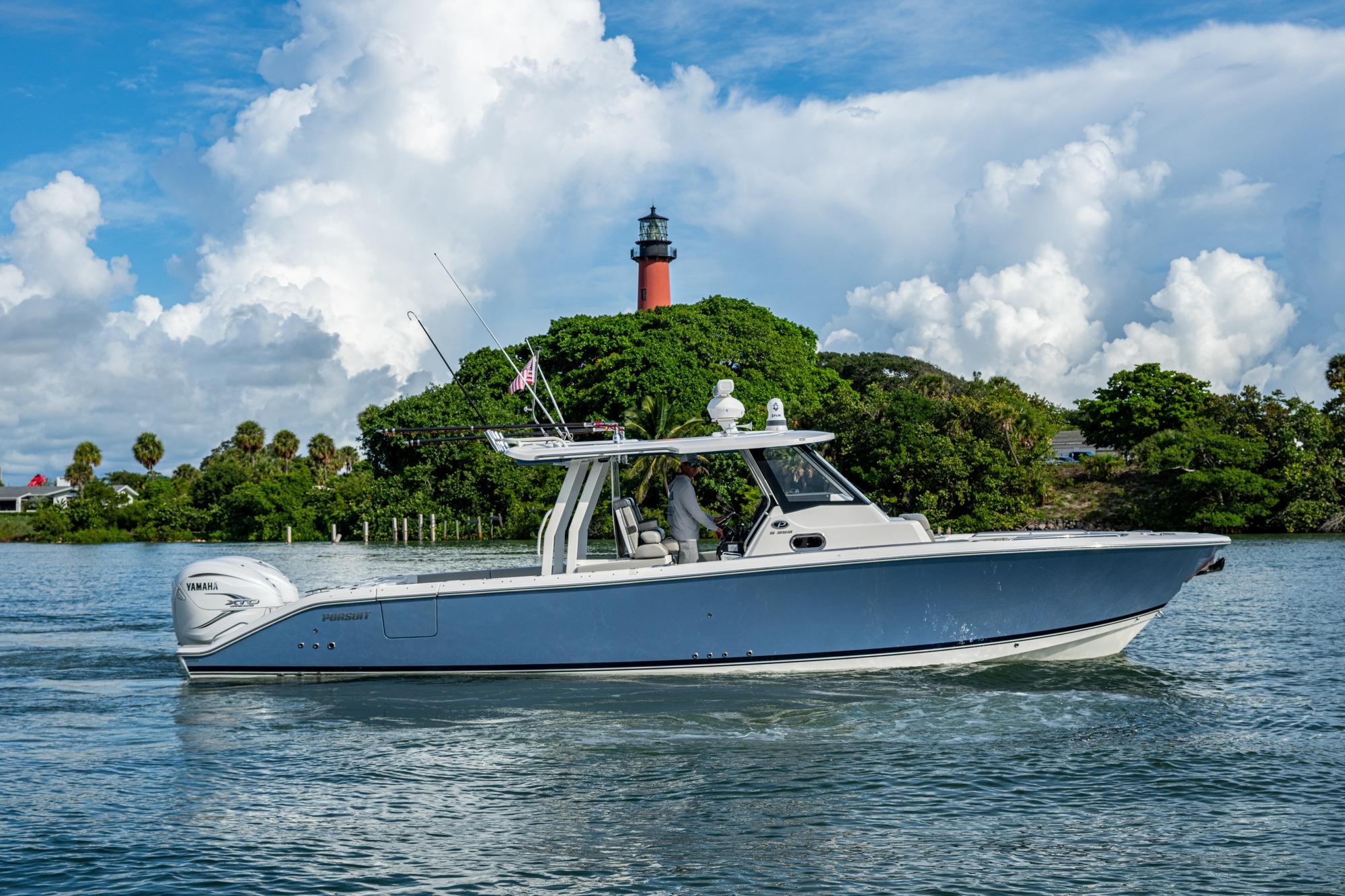 Pursuit S 358 Sport 2023 Pursuit S 358 Sport boat cruising near lush island and lighthouse.