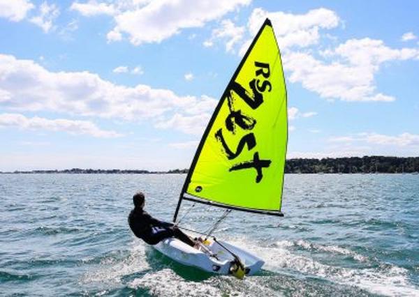 RS Zest 2024 RS Zest sailboat on open water under a sunny sky.