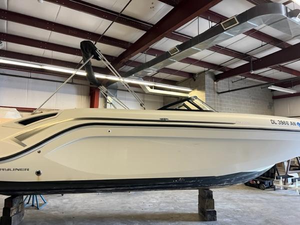 Bayliner DX 2200 2021 Bayliner DX 2200 boat in a warehouse, elevated on blocks.