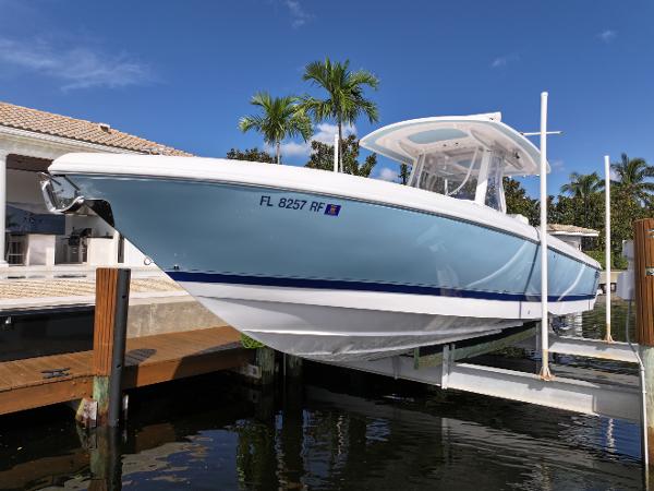 Intrepid 327 2017 Intrepid 327 boat docked, light blue hull, sunny day, palm trees in background.
