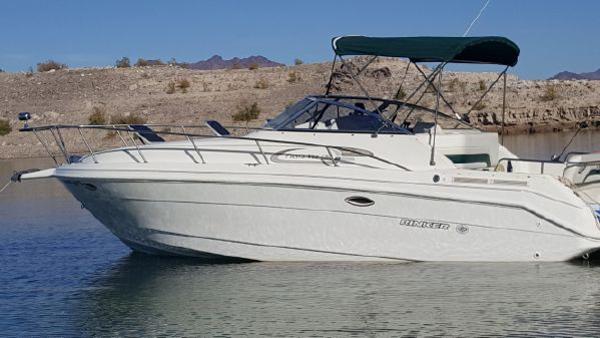 Rinker Fiesta Vee 280EC 1998 Rinker Fiesta Vee 280EC boat on calm water with rocky shoreline.