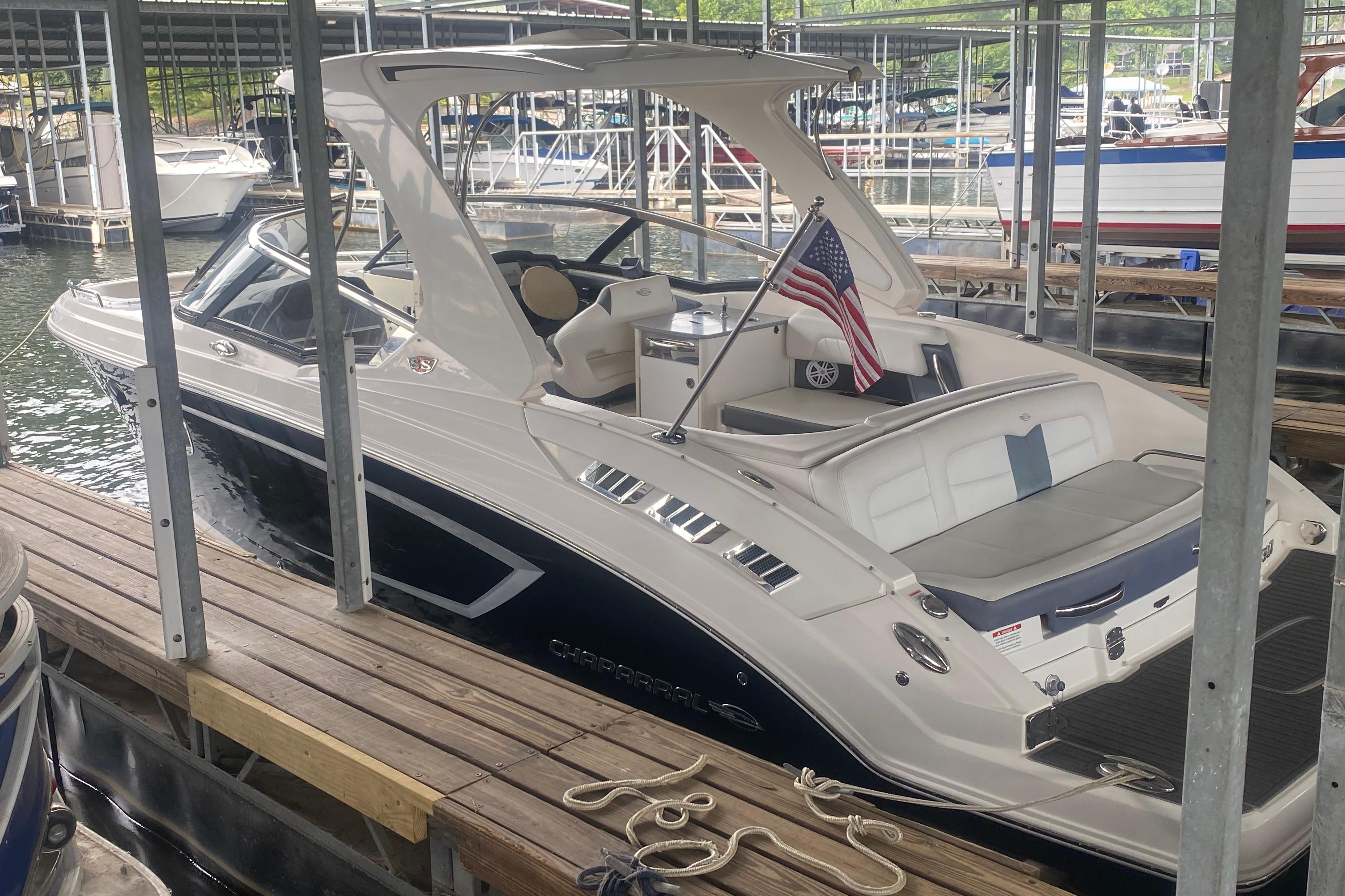 Chaparral 307 SSX 2015 Chaparral 307 SSX boat docked, featuring sleek design and American flag.