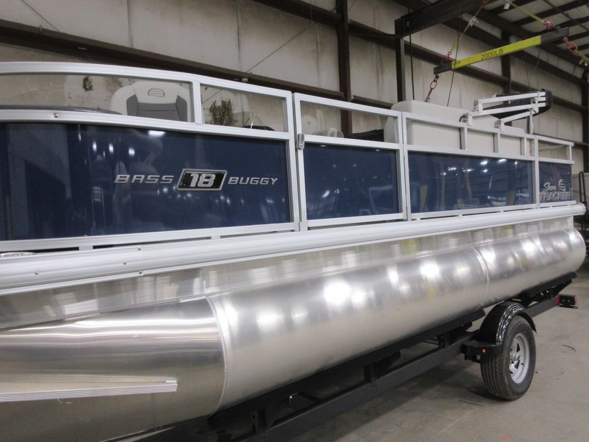 Sun Tracker Bass Buggy 18 DLX 2026 Sun Tracker Bass Buggy 18 DLX pontoon boat in a warehouse setting.
