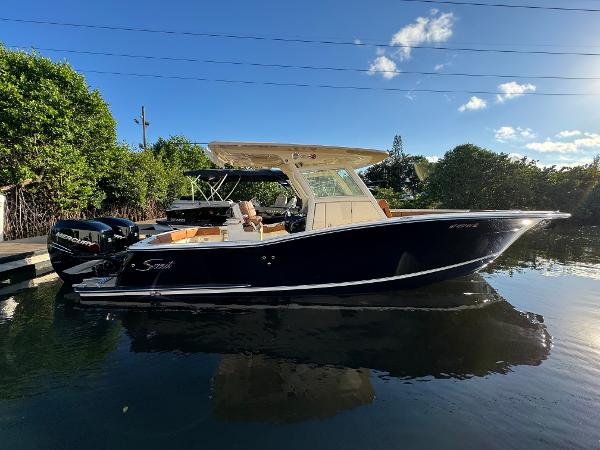 Scout 300 LXF 2018 Scout 300 LXF boat docked on calm water under clear sky.