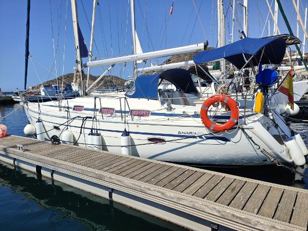 Bavaria 39 Cruiser Bavaria 39 Cruiser 2006 sailboat docked at marina with blue canopy and lifebuoy.