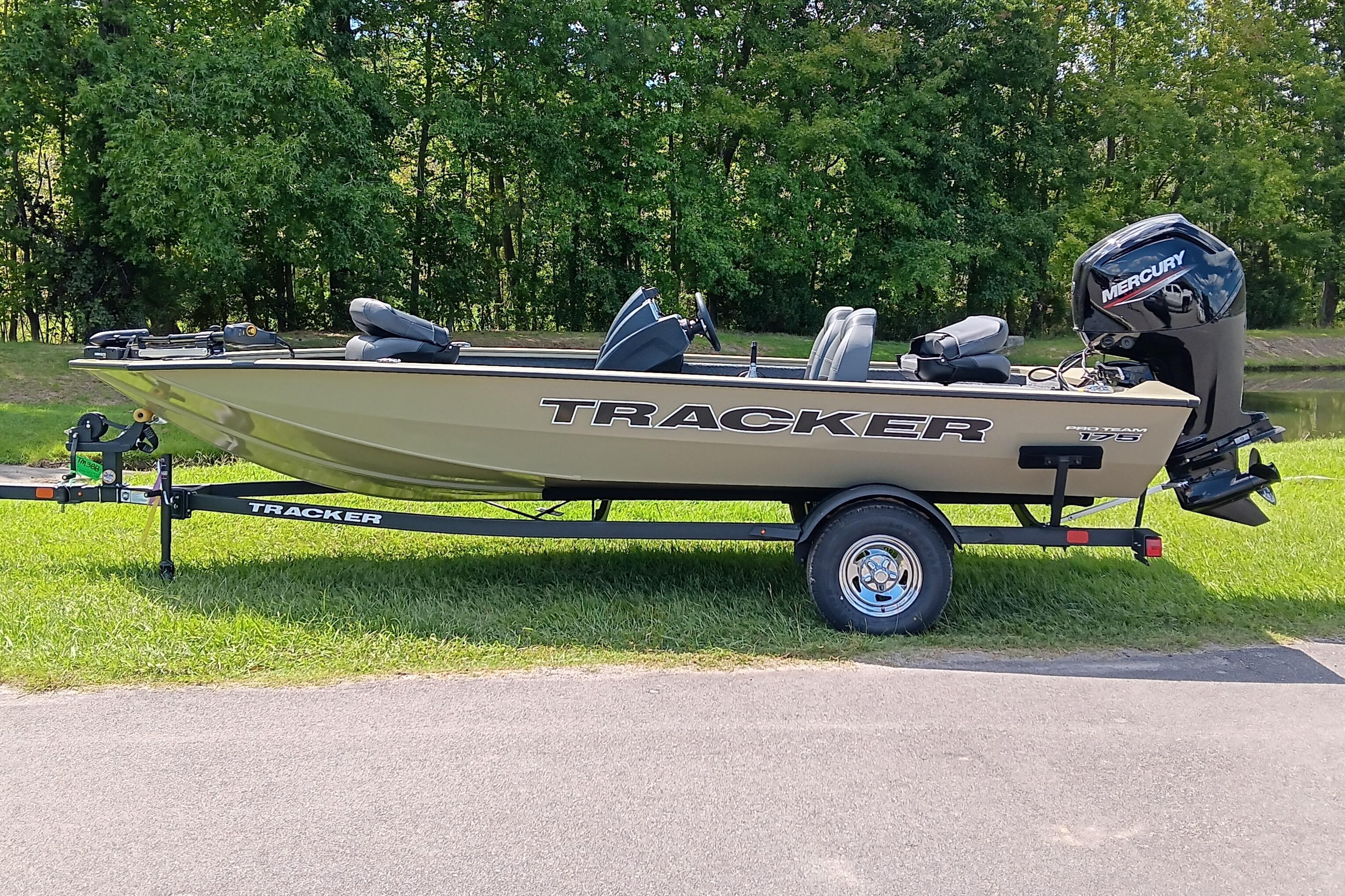 Tracker Pro Team 175 2026 Tracker Pro Team 175 boat on trailer, parked on grass with trees in background.