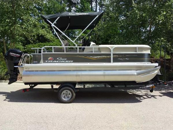 Sun Tracker Party Barge 18 DLX 2025 Sun Tracker Party Barge 18 DLX pontoon boat on trailer, parked outdoors.