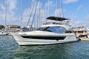 Beneteau Monte Carlo 52 2022 Beneteau Monte Carlo 52 yacht docked in a marina under a clear blue sky.