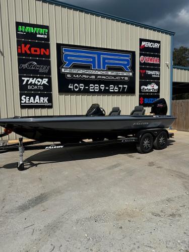 Falcon F205 2025 Falcon F205 boat on trailer outside marine shop with various brand logos.