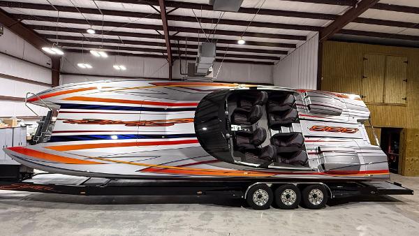Skater 388 2020 Skater 388 powerboat with vibrant orange and blue stripes in a warehouse setting.