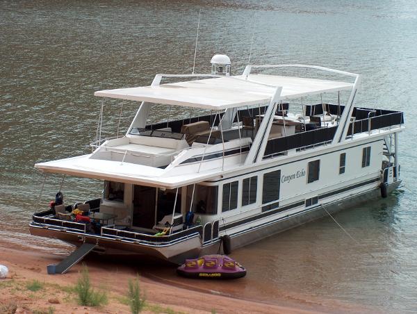 Stardust Cruisers Multi Owner Houseboat 2005 Stardust Cruisers Multi Owner Houseboat docked on a lake shore.