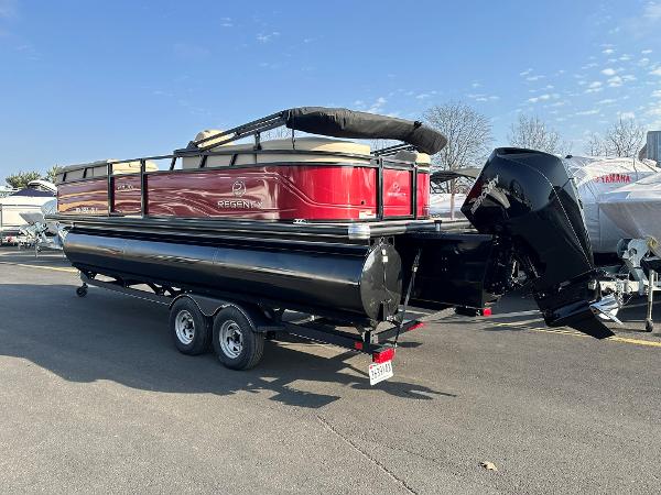 Regency 230 DL3 2023 Regency 230 DL3 pontoon boat on trailer, featuring a sleek red and black design.