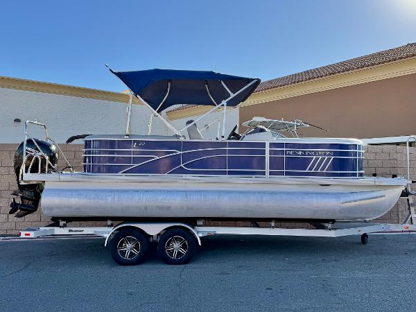 Bennington 22 LSR 2021 Bennington 22 LSR pontoon boat on trailer with blue canopy.