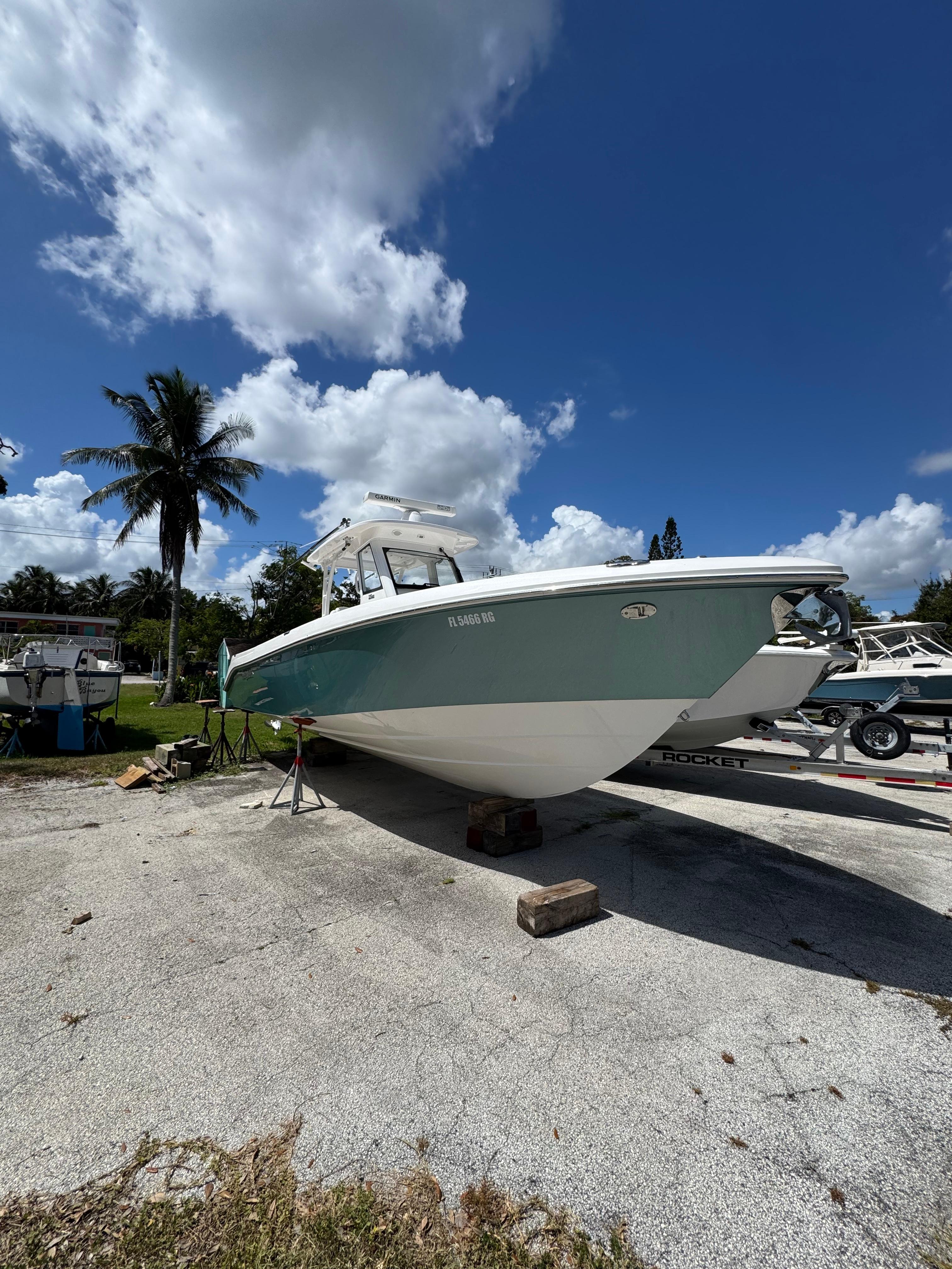 Everglades 325 Center Console 2016 Everglades 325 Center Console boat on land under a clear blue sky.
