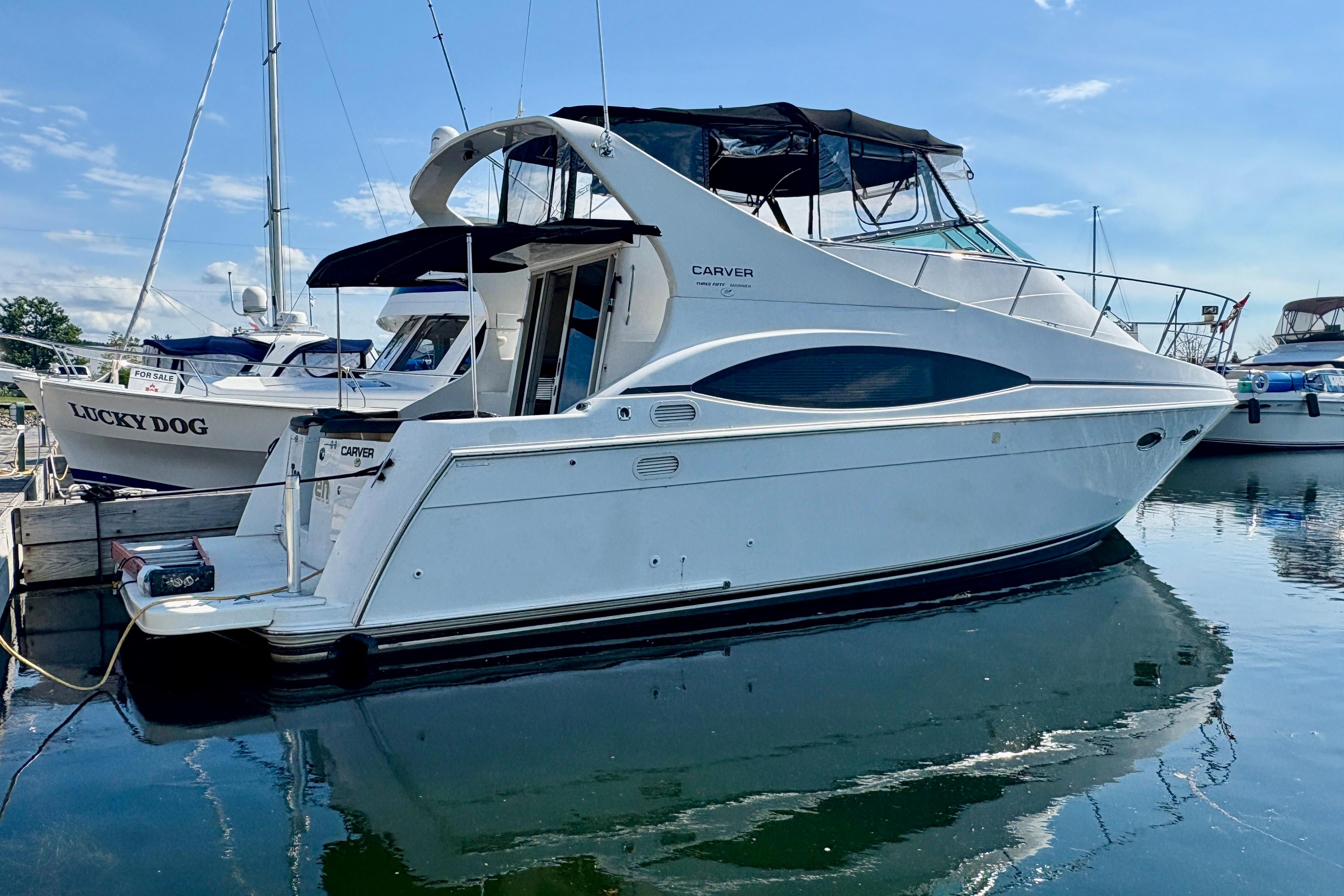 Carver 350 Mariner 1999 Carver 350 Mariner yacht docked at marina, reflecting on calm water.
