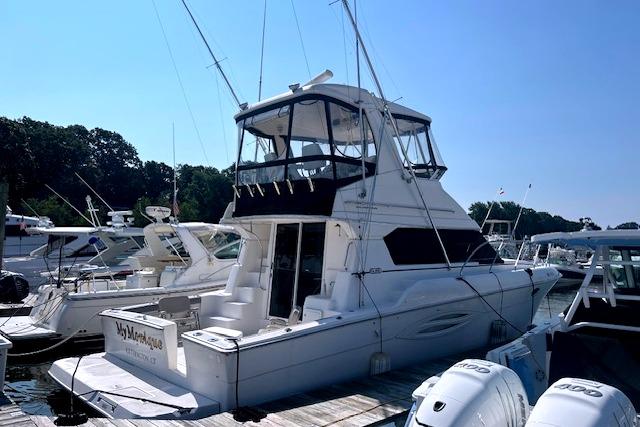 Silverton 42 Convertible 2002 Silverton 42 Convertible yacht docked at marina, featuring spacious deck and flybridge.